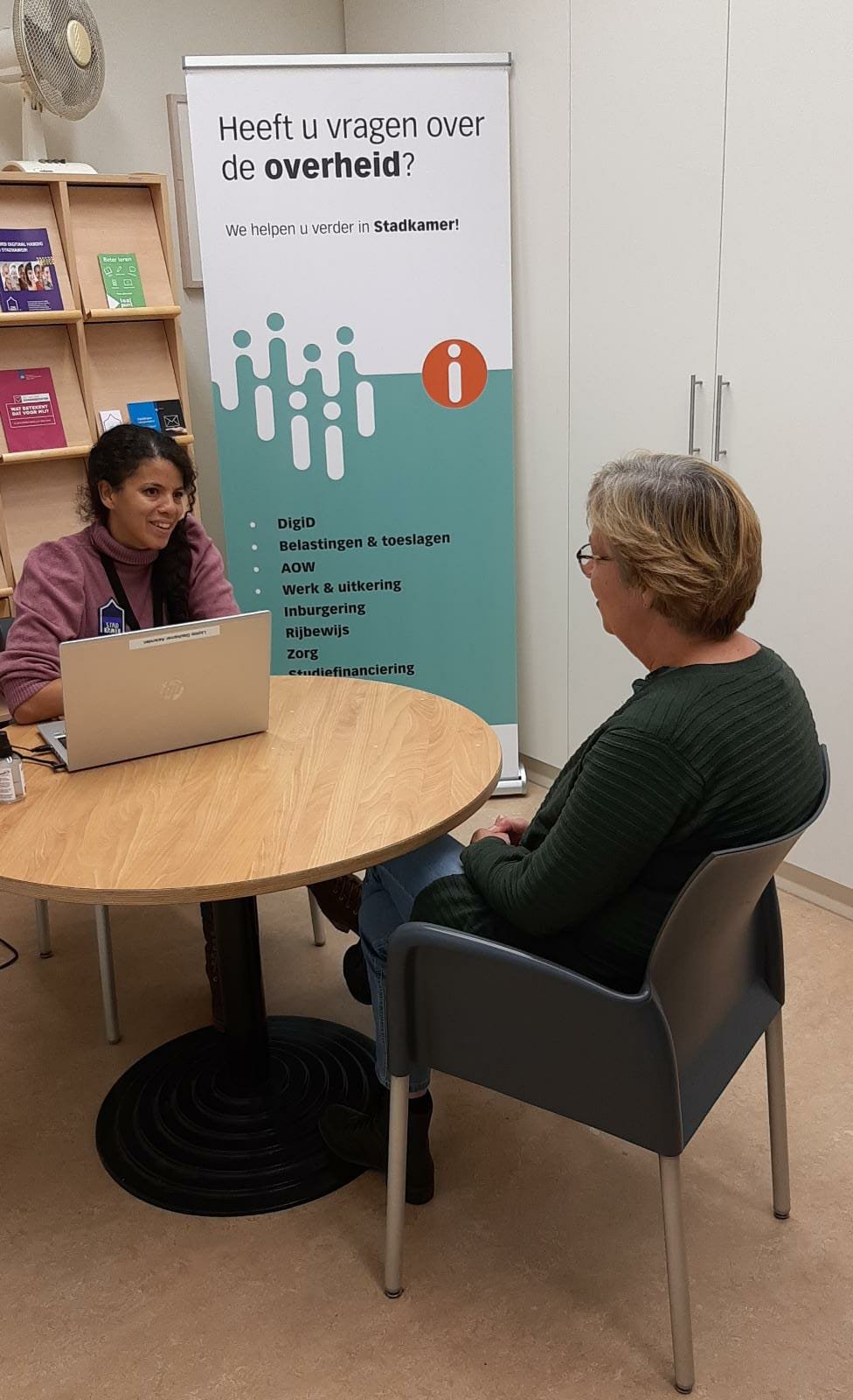 Twee mensen bij het Informatiepunt Digitale Overheid