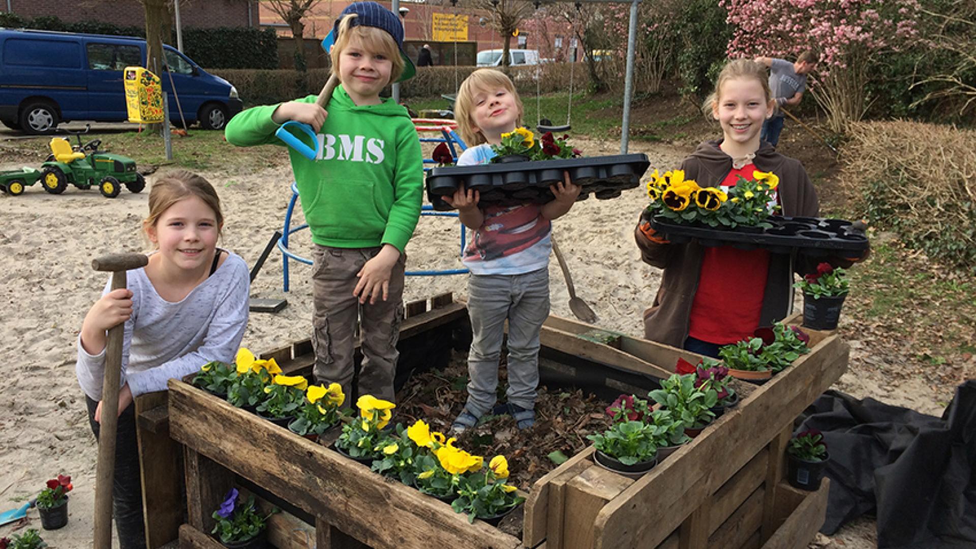 Kinderen aan de slag met het plaatsen van planten.